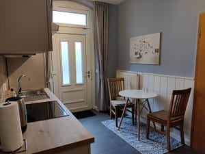 Küche mit rundem Tisch und zwei Stühlen, Blick Richtung Ausgang